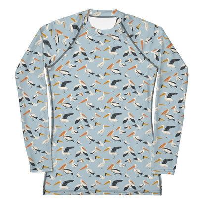 A women’s rash guard featuring a playful pelican print with shades of blue and white, shown from the front.