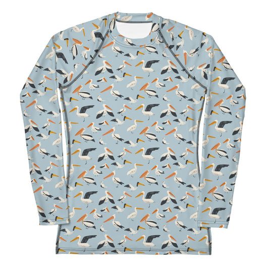A women’s rash guard featuring a playful pelican print with shades of blue and white, shown from the front.
