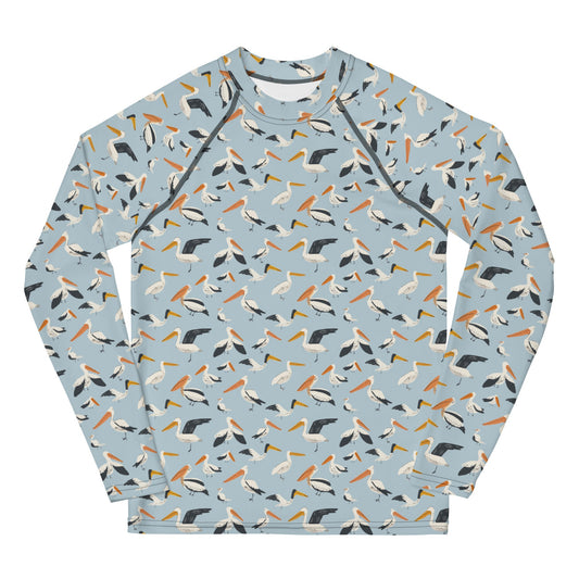 A teen’s rash guard featuring a playful pelican print with shades of blue and white, shown from the front.