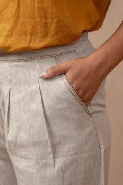 Closeup of Dhara | Pleated Wide Leg Pants in Natural Hemp on woman with left hand in pocket.