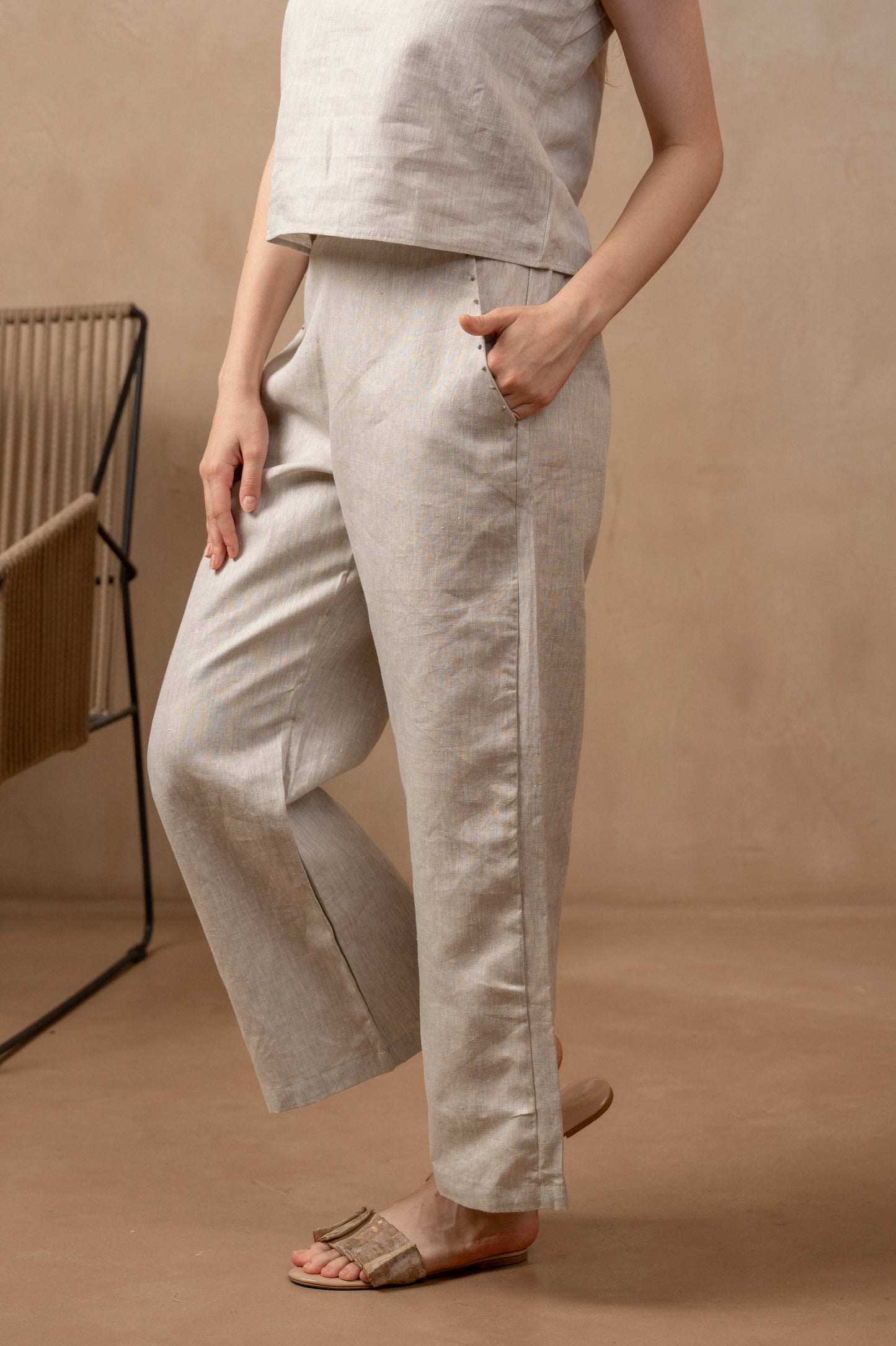 Partial left front view of woman wearing Taru | Wide Leg Ankle Pants, right hand on leg and left hand in pocket.