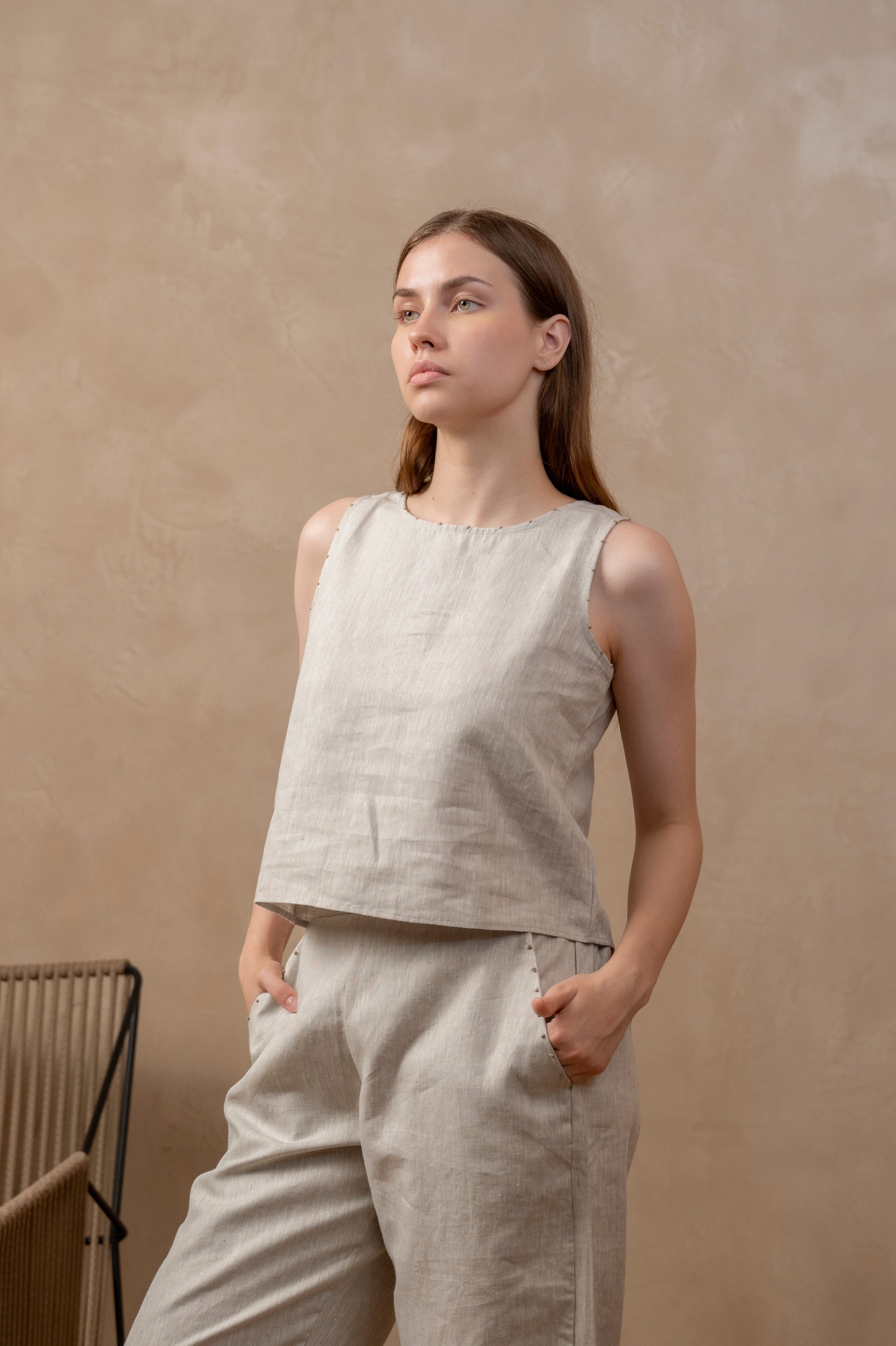 Woman wearing sleeveless Top in Natural Hemp Sustainable Fabric - Linen wear. Hands are in pockets.