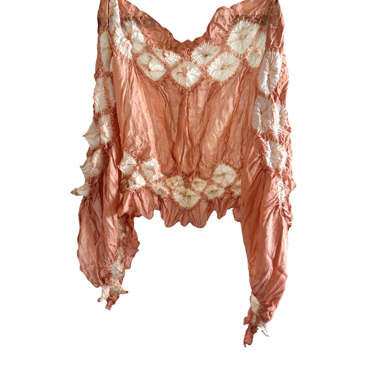 Natural sappanwood-dyed silk scarf in terracotta orange with white diamond shapes, hanging on a white background.