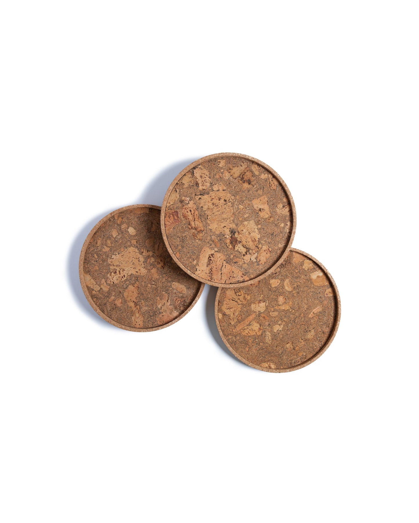 Top view of three circular cork Lazy Susan spinning trays with acacia wood base.