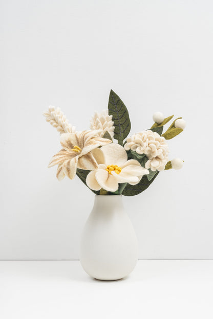 White vase with a bouquet of crisp white felt flowers on a white background. Handmade in Nepal by artisans earning a fair wage.