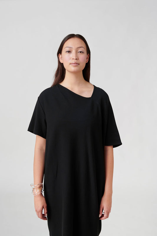 Front view of woman wearing black dress.