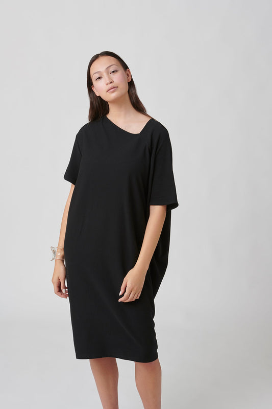 Front view of woman wearing black dress.