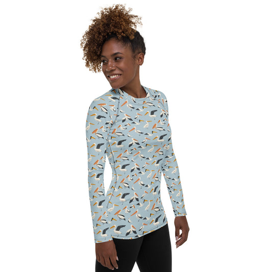 A stylish women’s rash guard featuring pelican illustrations on a blue and white base, shown from the front.