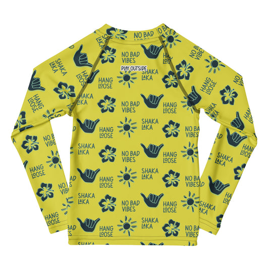 Yellow rashguard with navy designs of the sun, hibiscus flowers, hang loose hand sign, and the words hang loose, no bad vibes, and shaka laka.