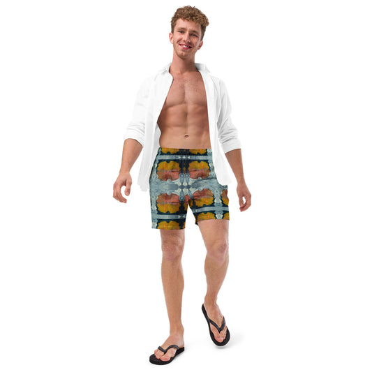 Man wearing multi colored print swim trunks and white open shirt.