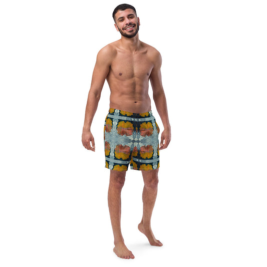 Front view of man wearing multi colored print orange and dark blue swim trunks.