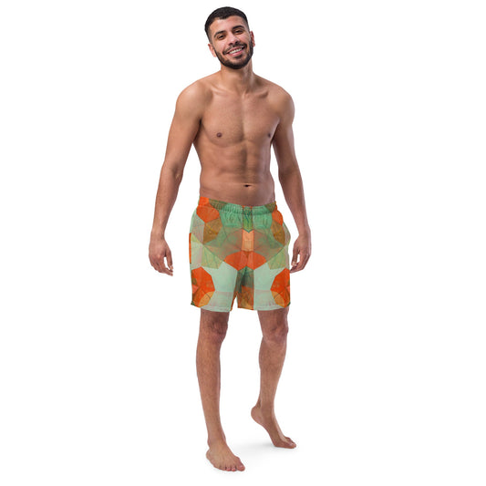 Front view of man wearing multi colored geometric print orange and green swim trunks.