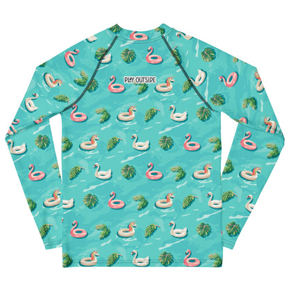 Aqua blue rash guard with images of pink floaty toy unicorns, swans, and Flamingos and green tropical leaves.