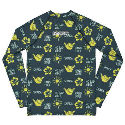 Dark blue rash guard with yellow designs of the sun, hibiscus flowers, hang loose hand sign, and the words hang loose, no bad vibes, and shaka.