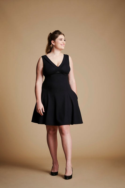 Woman wearing black flare dress with v neck.