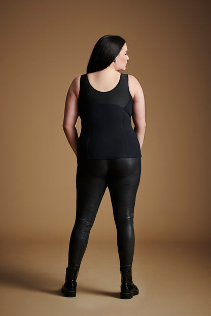 Back view of woman looking over right shoulder wearing black sleeveless v neck top.