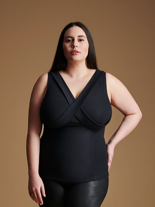 Woman wearing black sleeveless v neck top.