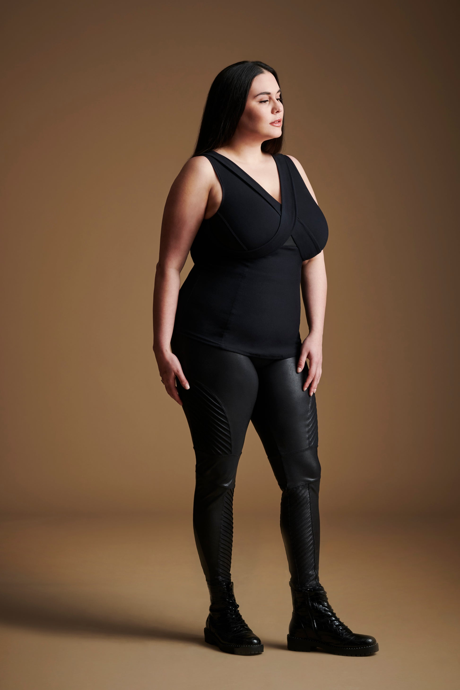 Front left view of woman wearing black sleeveless v neck top.