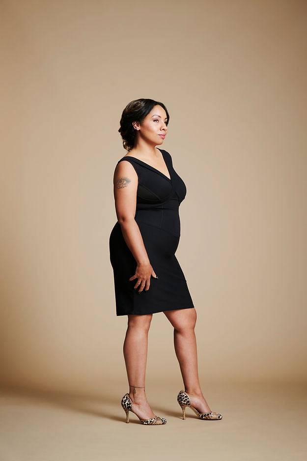 Right side view of Women wearing a black dress, right hand at her side.