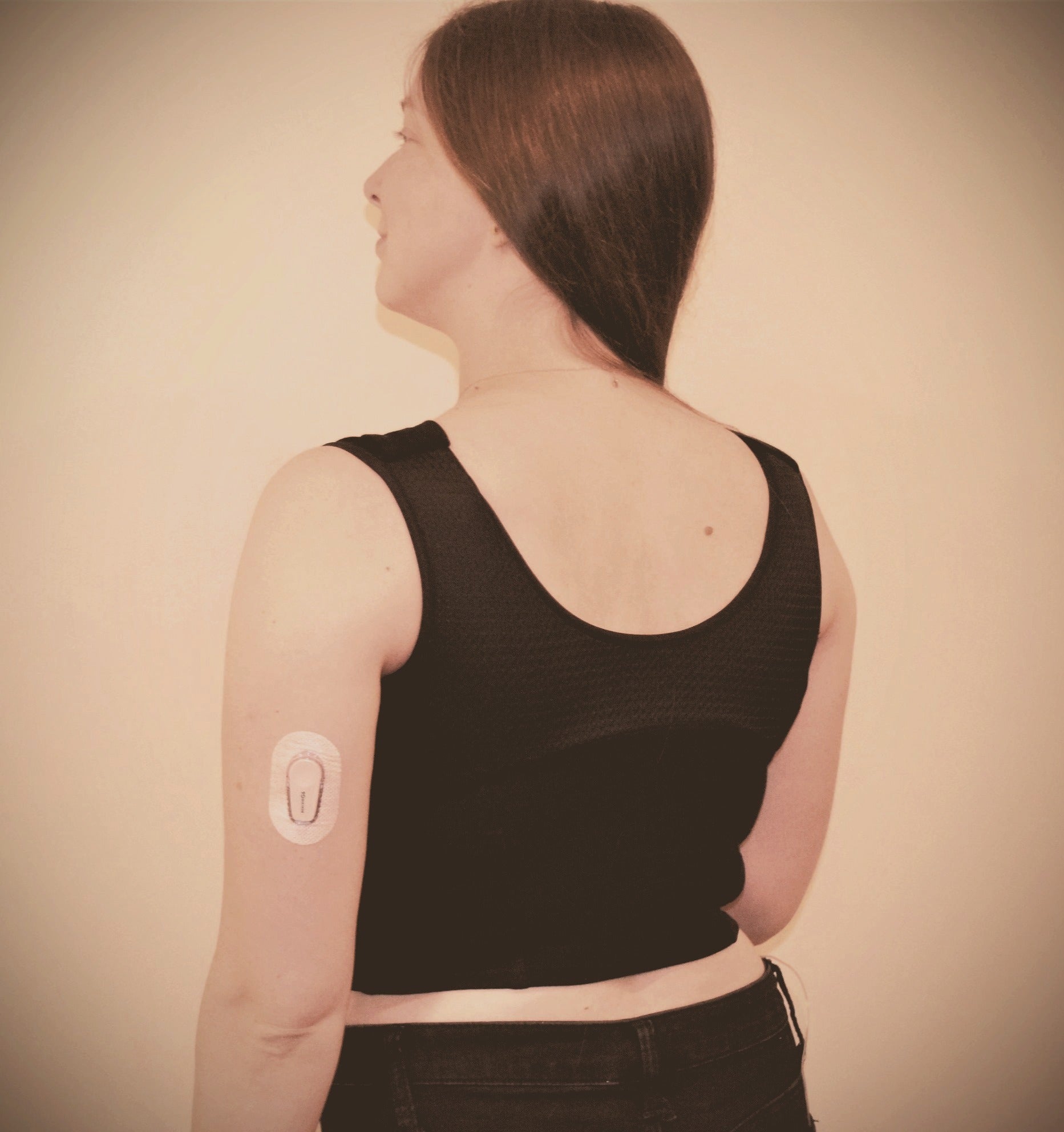 Back view of woman wearing black waist length crop top.