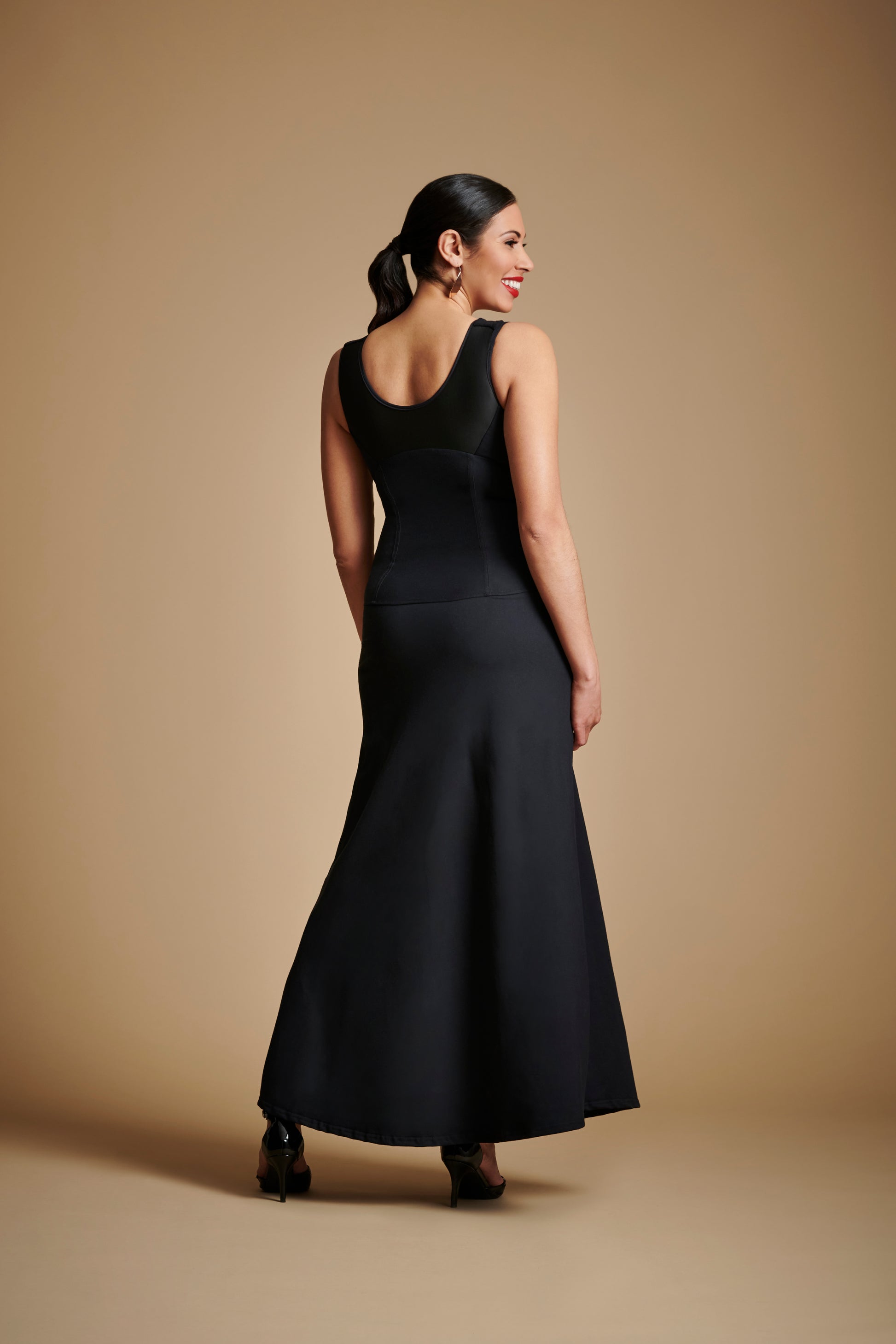 Back view of woman wearing long black dress with scoop back.