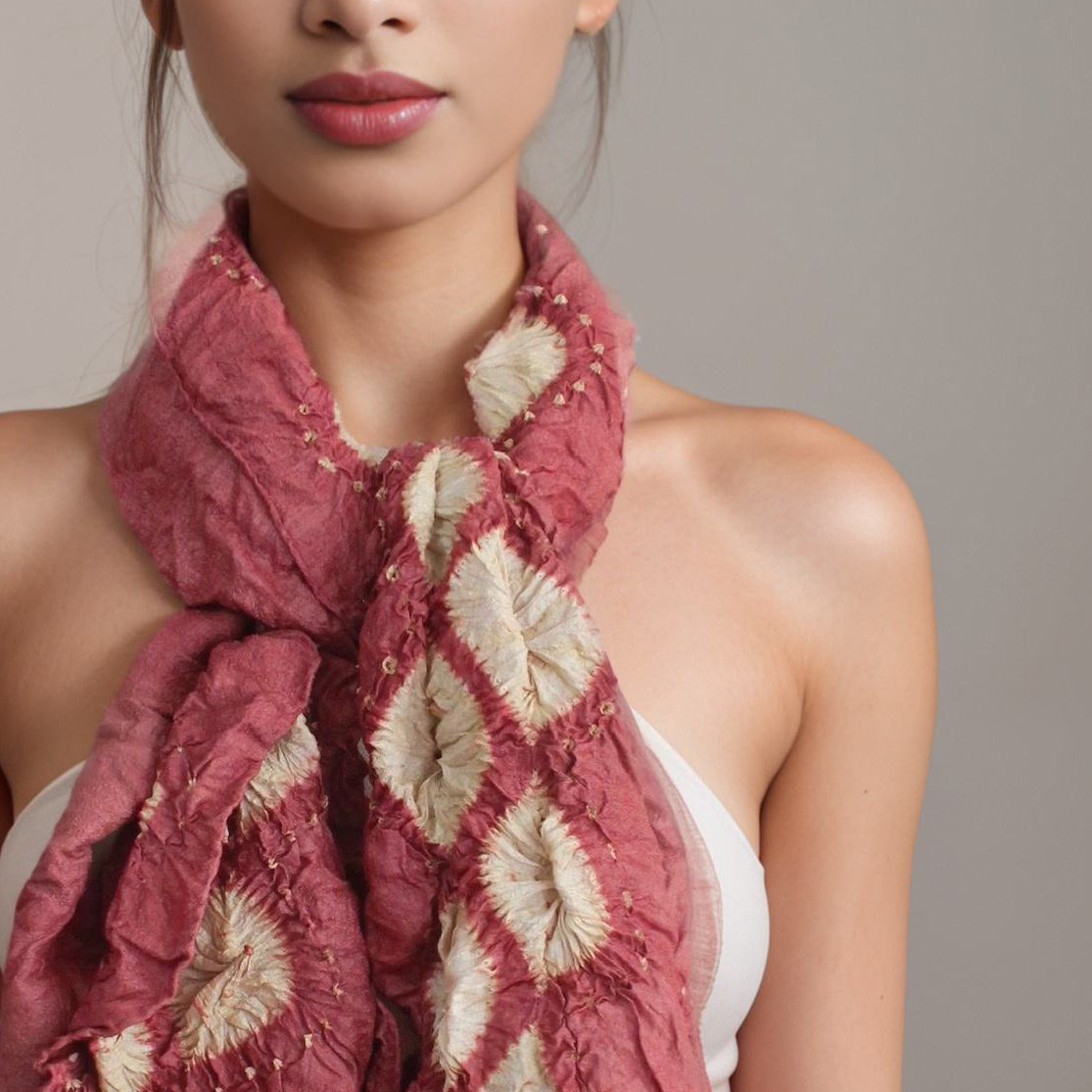 Closeup of woman wearing red and white silk scarf.