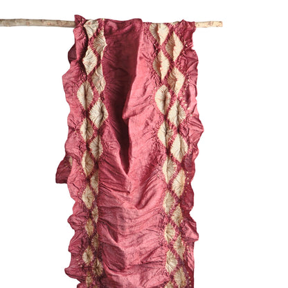 Red and natural scarf hanging on branch.