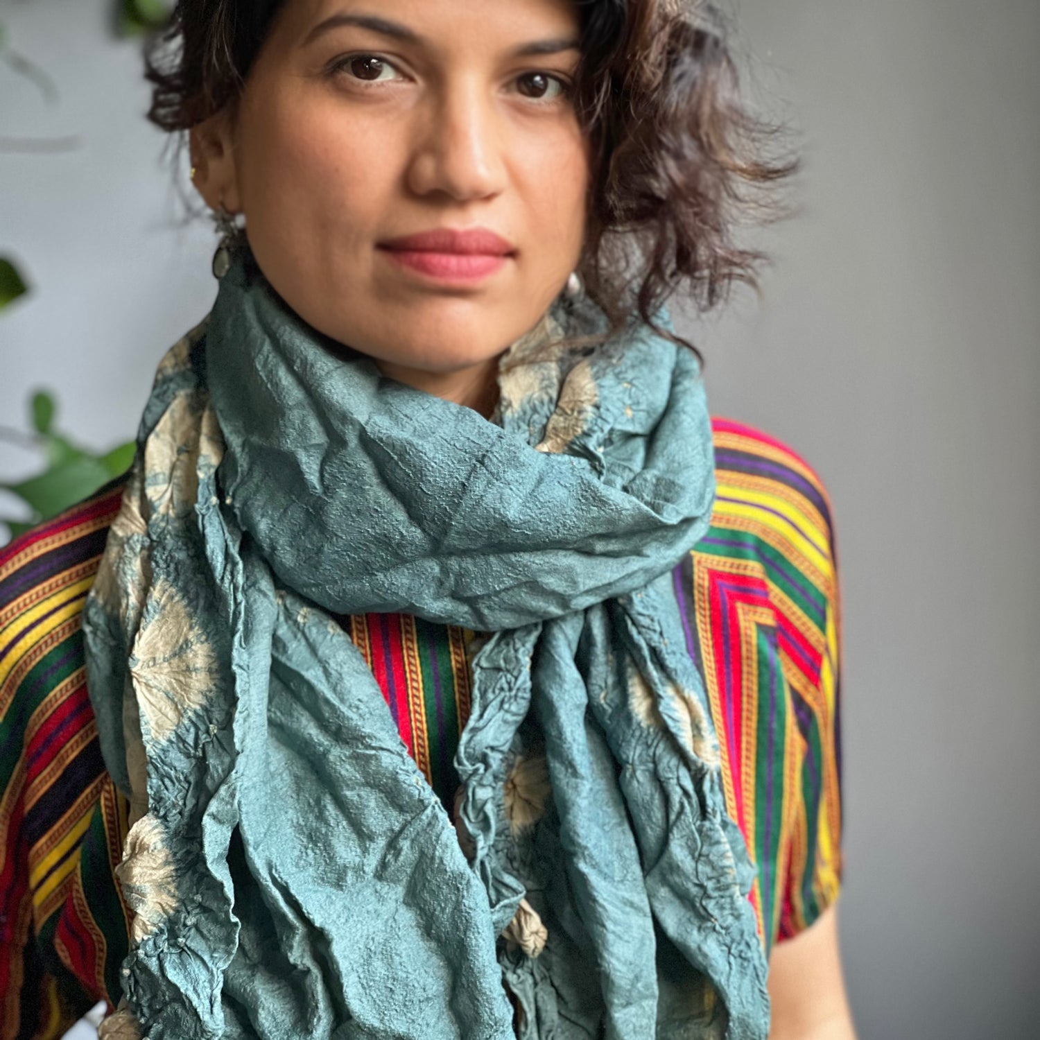 Woman wearing blue and natural colored tie dye scarf.