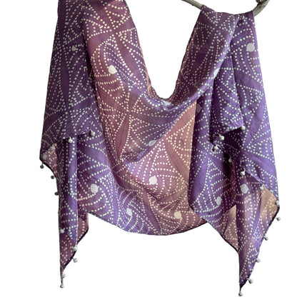 Purple and white geometric shapes scarf draped on branch.