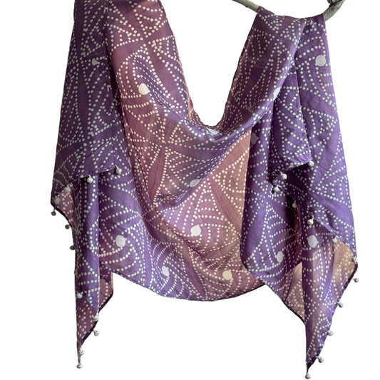 Purple and white geometric shapes scarf draped on branch.