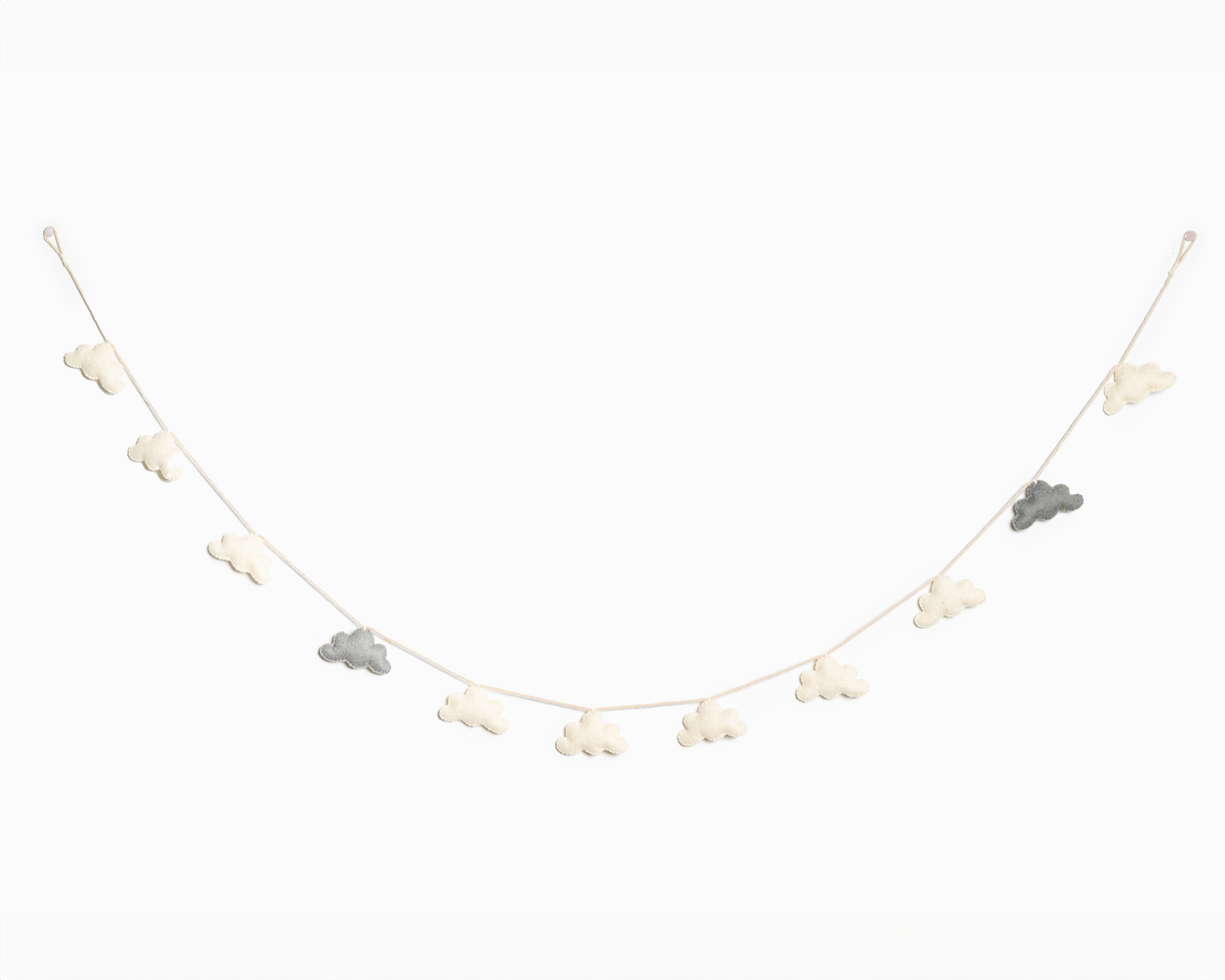 Grey and white felt cloud garland hanging on a white wall.