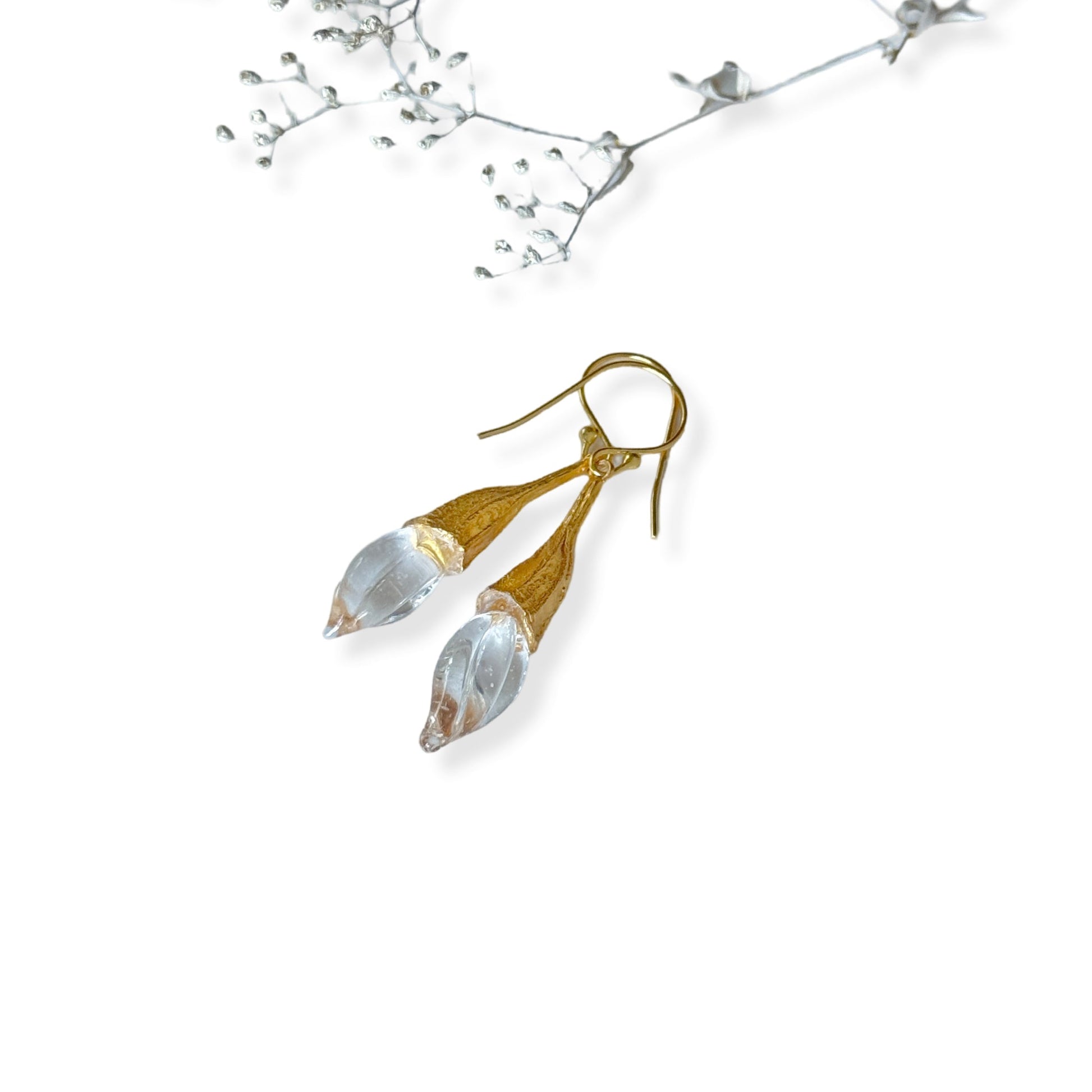 Pair of clear twisted glass bud earrings with gold findings.