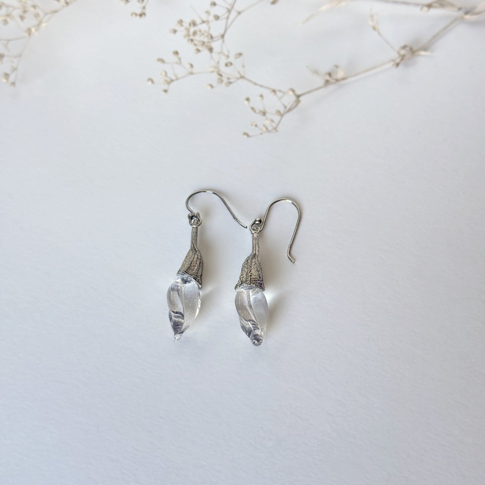 Pair of clear twisted glass bud earrings with silver findings.