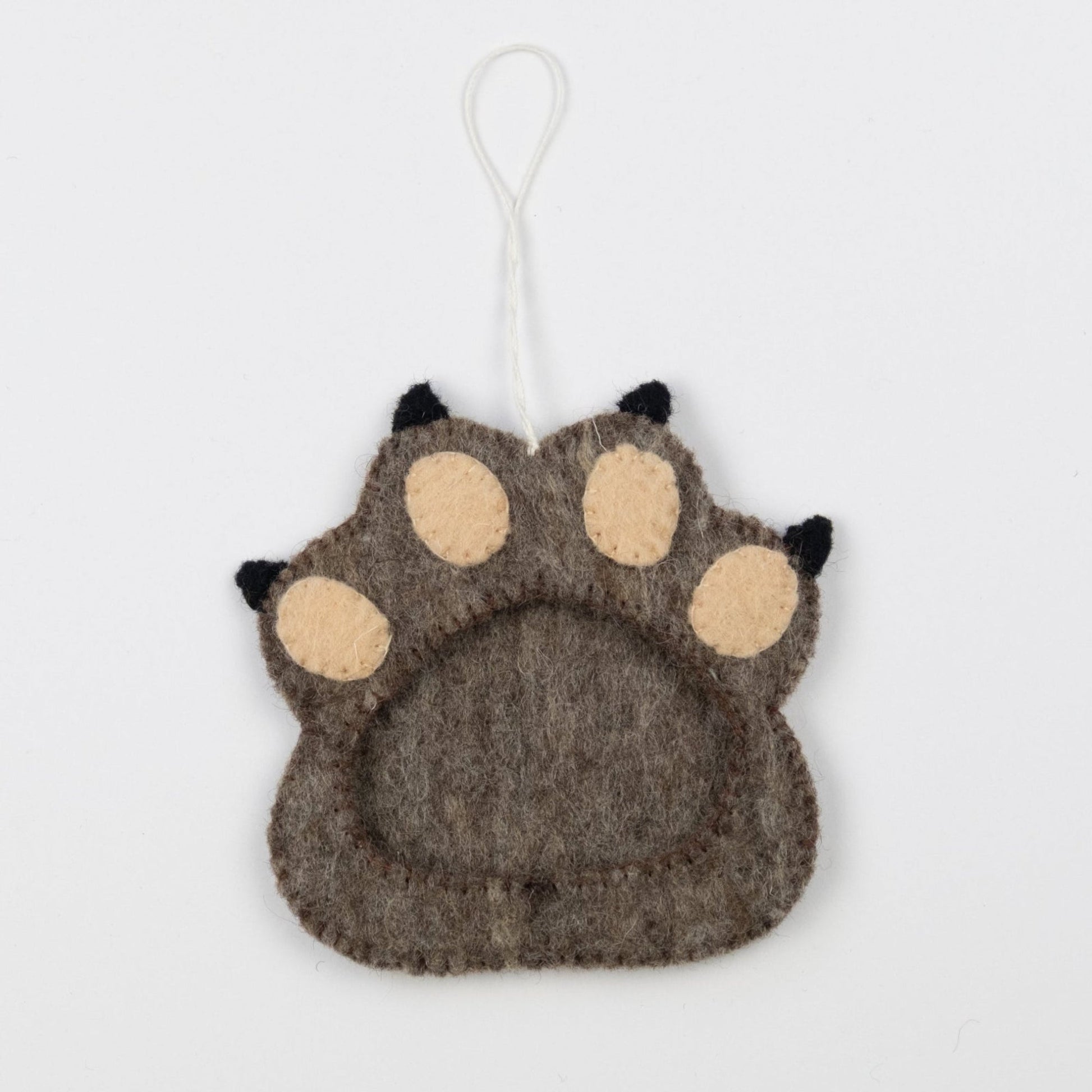 Felt ornament of brown paw print with a frame in the middle.