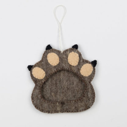 Felt ornament of brown paw print with a frame in the middle.
