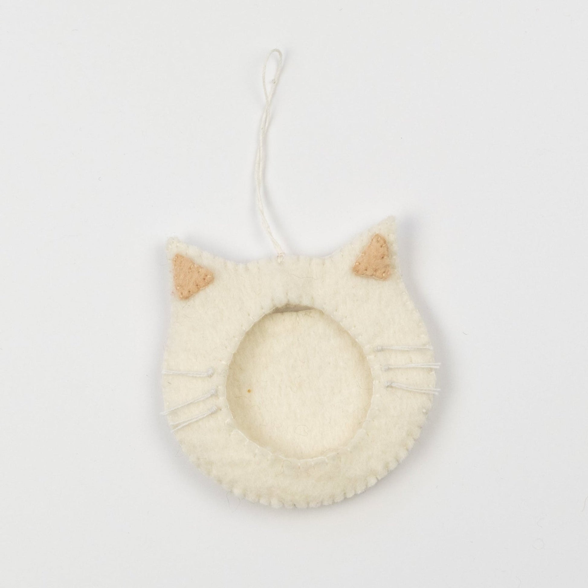 Felt ornament of a white cat face outline with a frame in the middle to put a photograph.