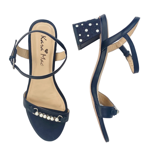 Front and side view of black sandal with silver accents across toe strap and on heel.