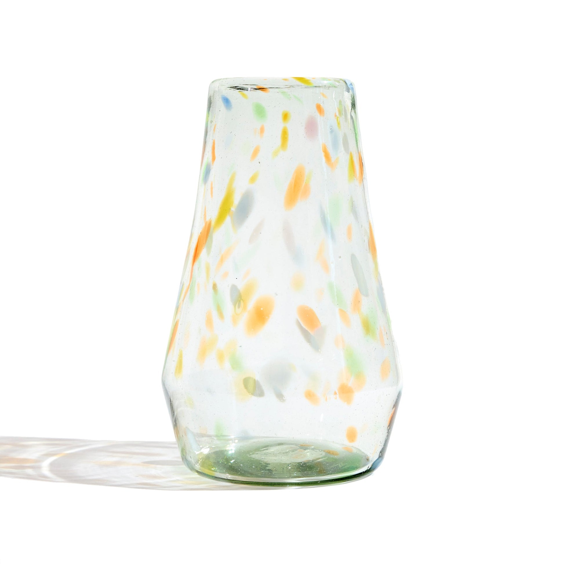 Clear vase with confetti markings of orange blue and green.