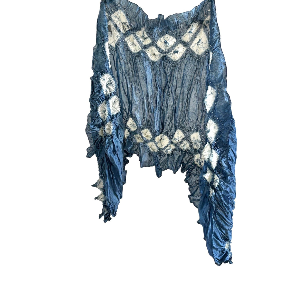 Natural indigo-dyed silk scarf in dark blue with white diamond shapes, hanging on a white background.