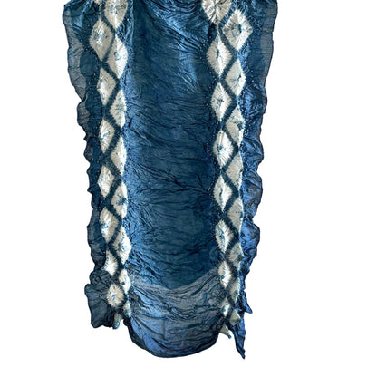 Natural indigo-dyed silk scarf in dark blue with white diamond shapes, hanging vertically on white background.