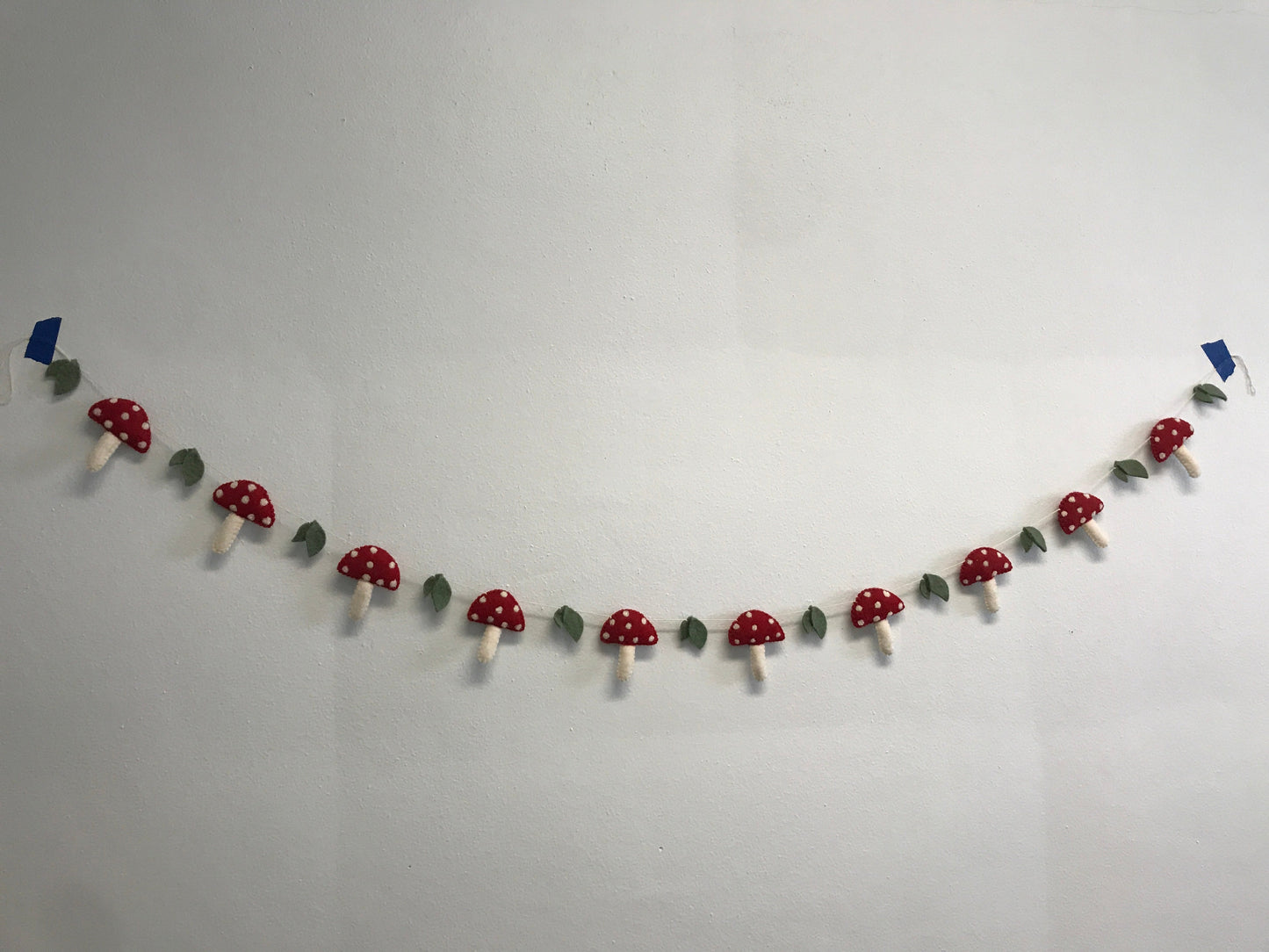 Felt garland of red mushrooms with white spots.