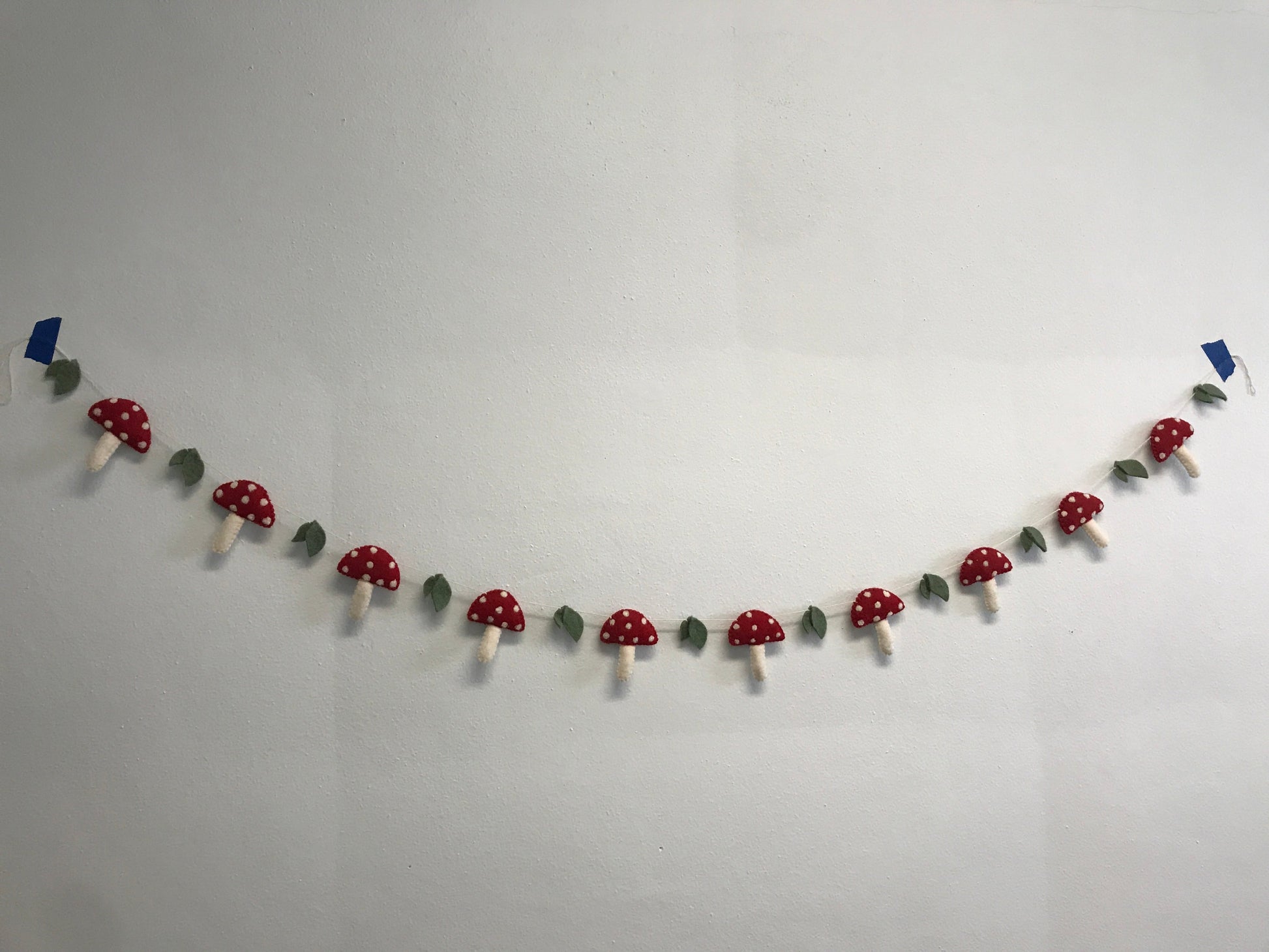 Felt garland of red mushrooms with white spots.