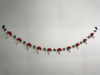 Felt garland of red mushrooms with white spots.