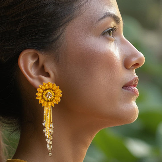 Front right view of woman wearing Pair of dahlia design earrings in red, yellow, green, and brown.