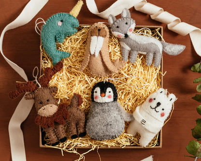 Felted wool ornaments of a narwal, walrus, fox, moose, penguin, and polar bear in a box.