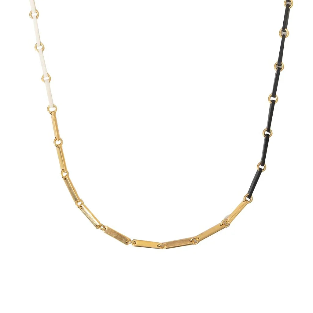 Close up of the bottom of a white, gold, and black link necklace.