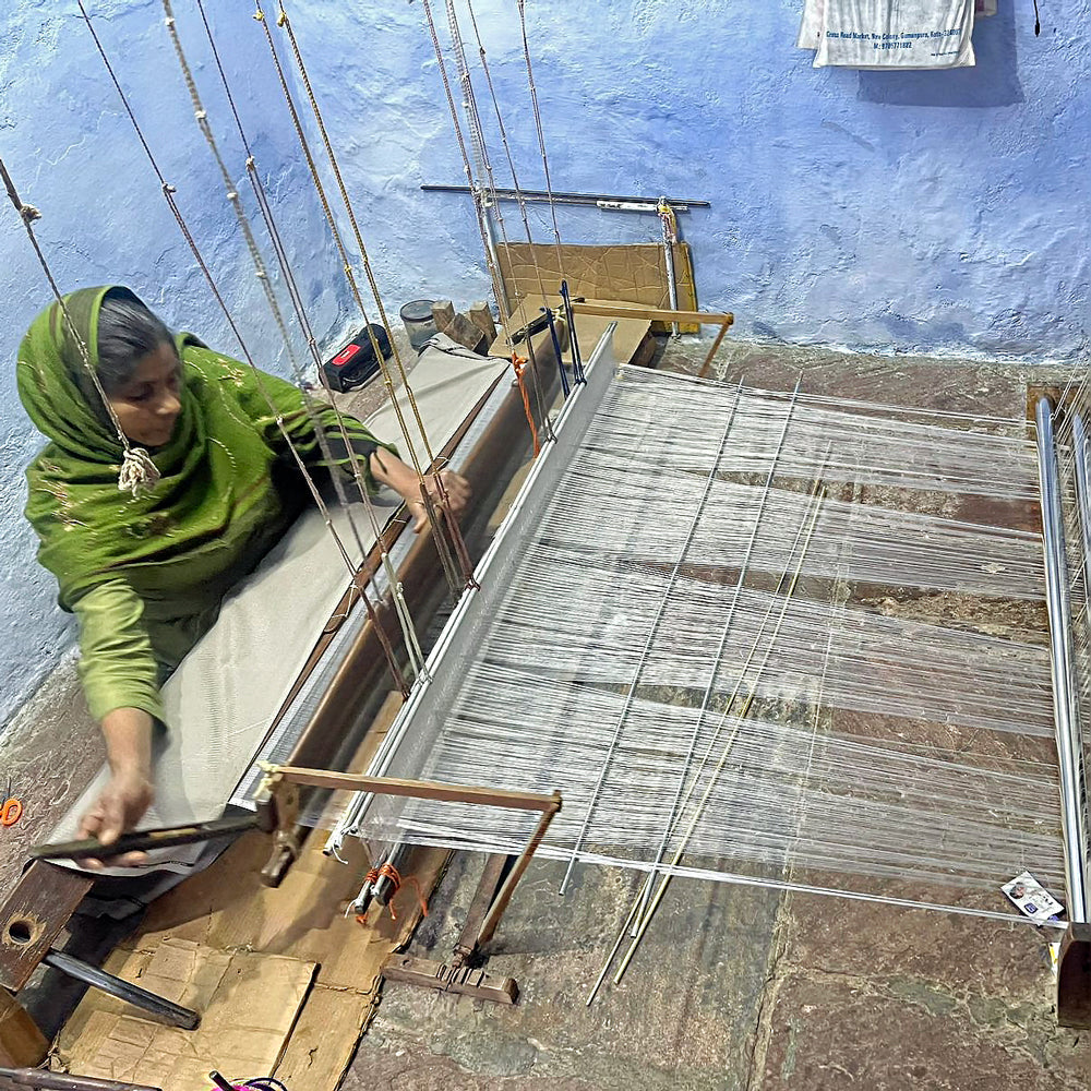 Woman artisan weaving silk on a wooden handloom in Kaithoon village, Rajasthan.