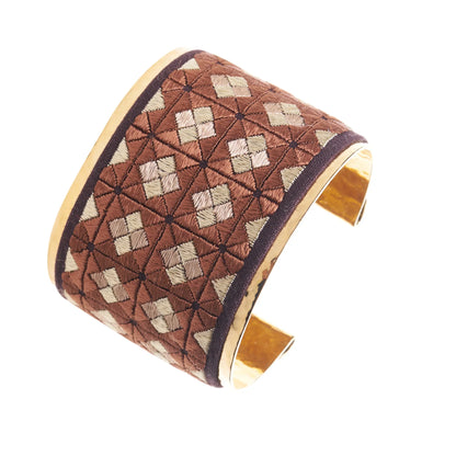 Artisan gold plated cuff bracelet with reddish brown and tan embroidery design.