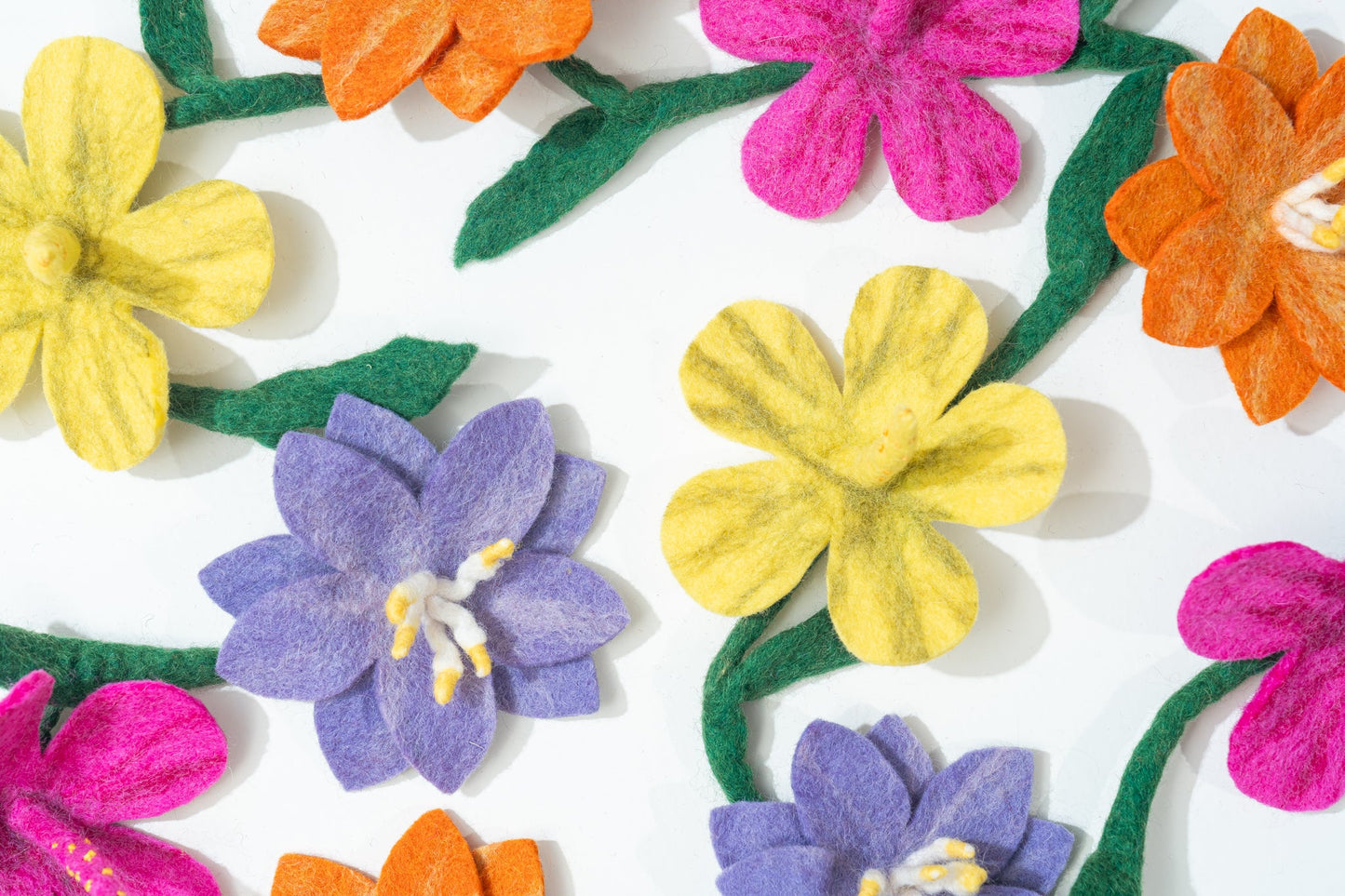 Colorful felt flowers on a white background handmade by women artisans in Nepal | Global Goods Partners