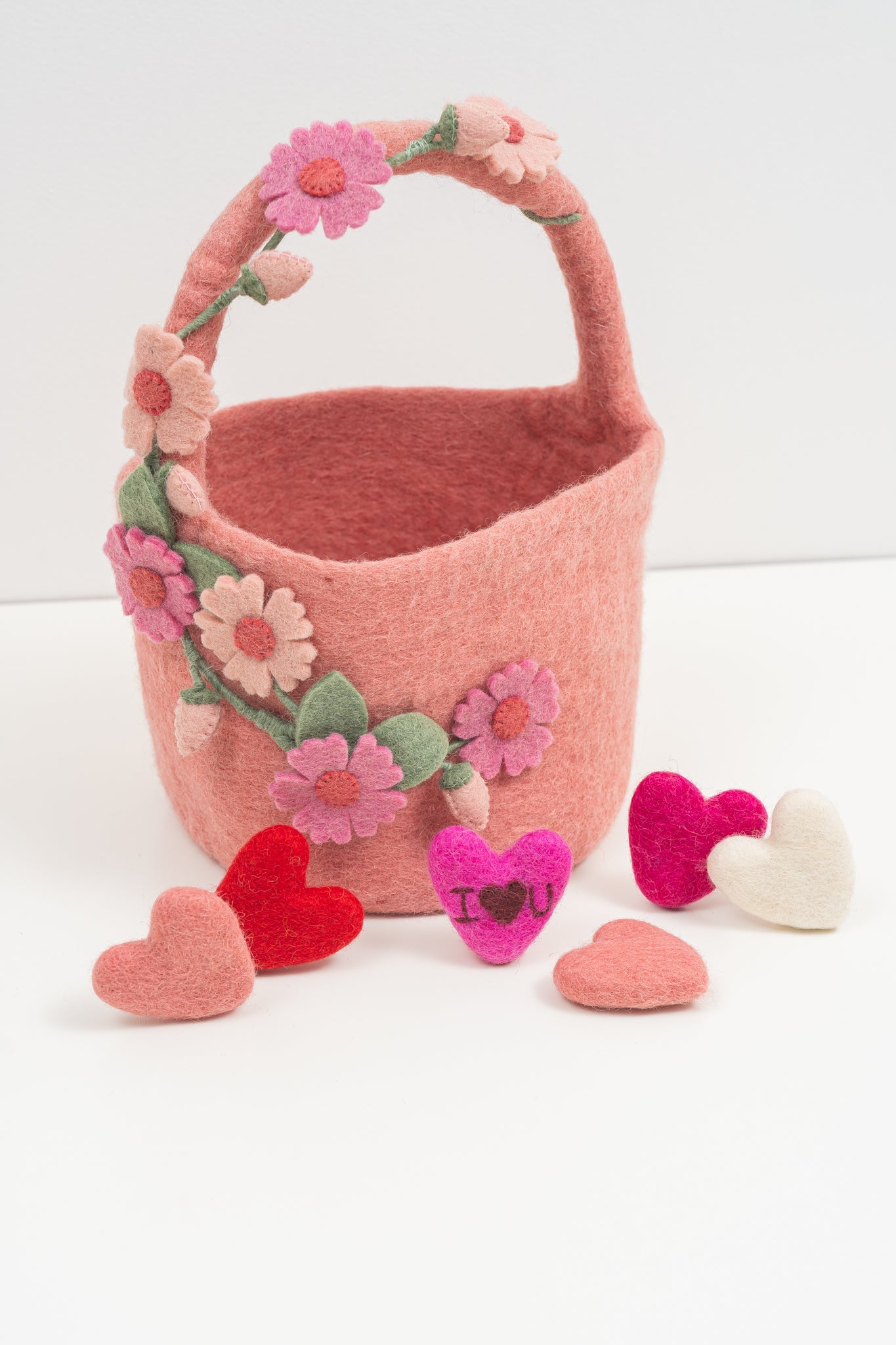 Handmade pink felt basket with floral and heart decorations on a white background | Global Goods Partners